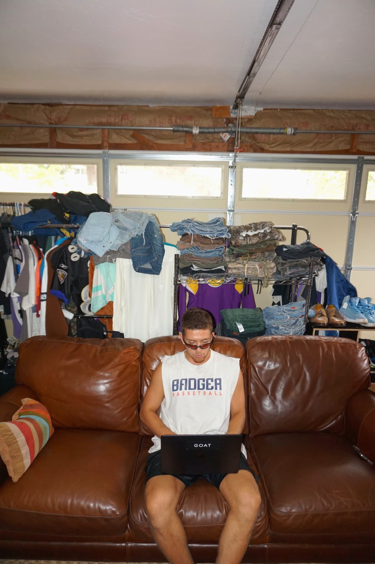 The garage where it started — racks of FoundF1rst inventory behind the couch