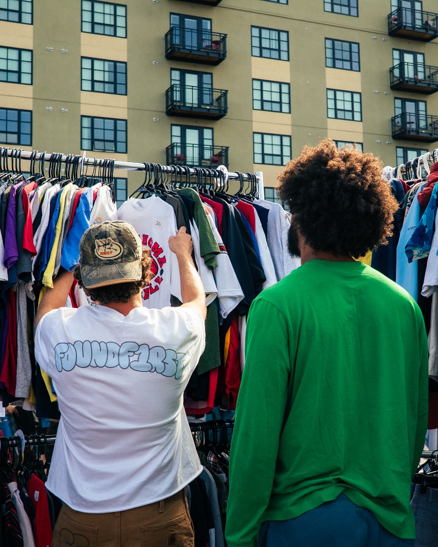 Shoppers digging through the FoundF1rst racks at an outdoor market